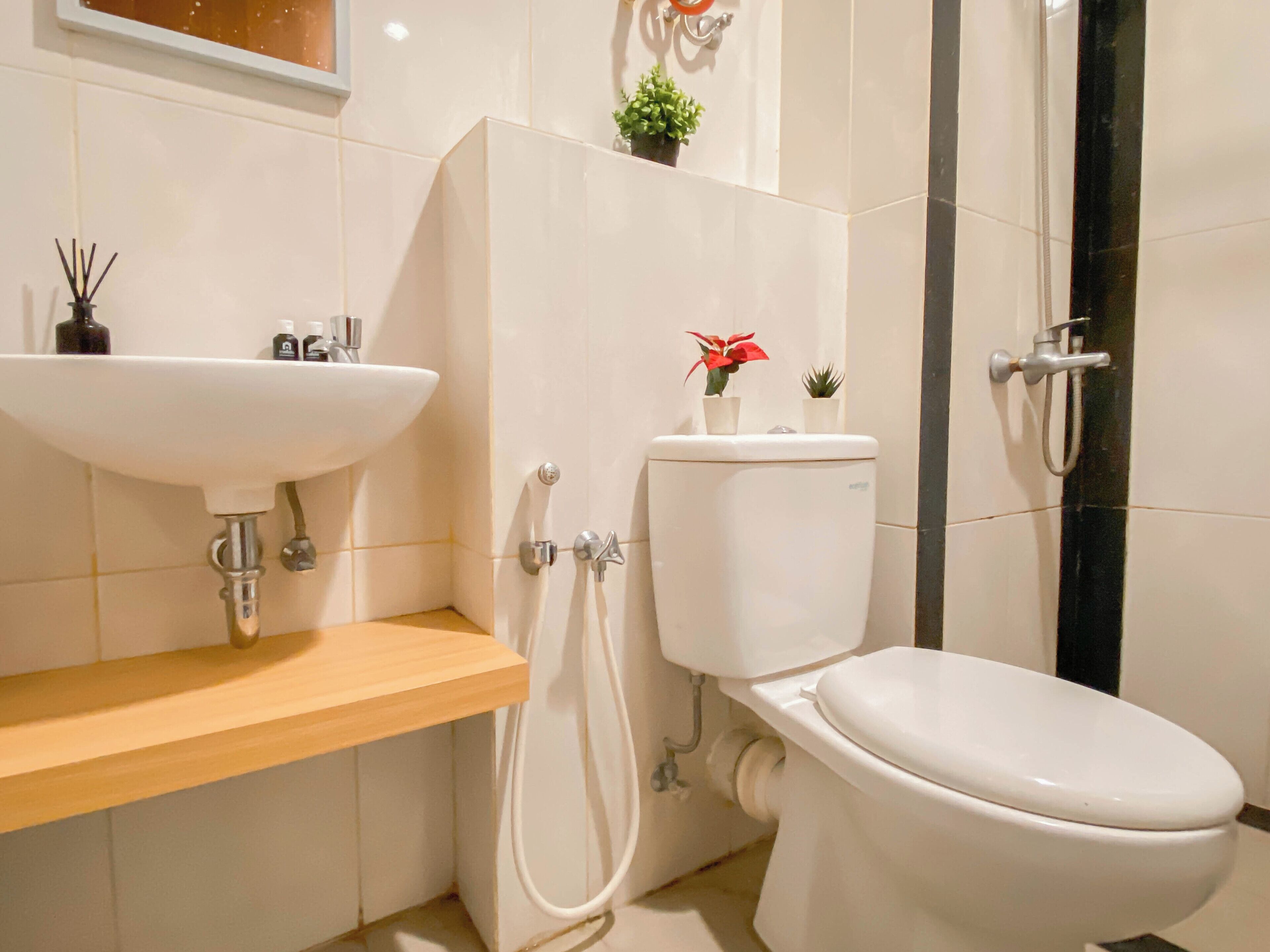 A modern bathroom with a white sink, toilet, and shower.
