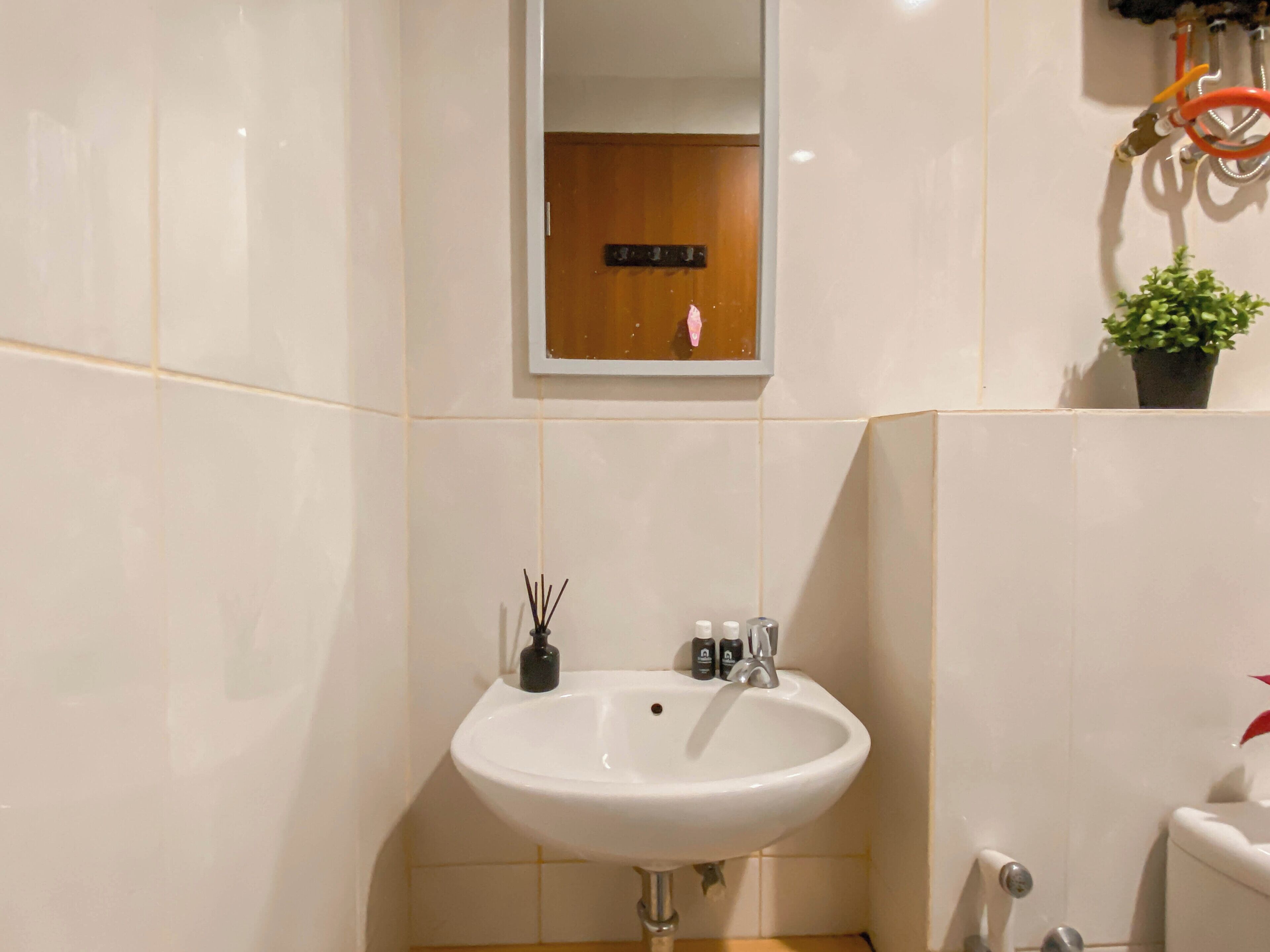 A bathroom with a white sink, a mirror, and a toilet.