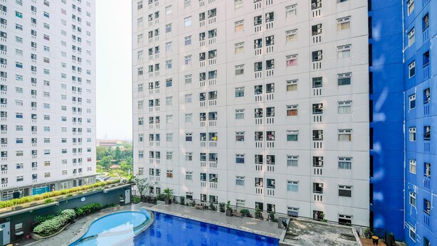 A modern building with a rooftop pool surrounded by high-rise residential buildings. - Comfy 2Br At Green Pramuka City Apartment (Jakarta)