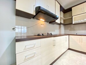 Køleskab, kogeplade, køkkentøj/tallerkener/redskaber, spisebord