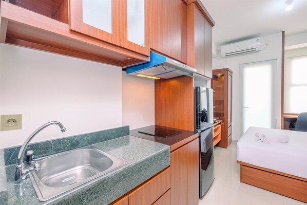 Fridge, stovetop, cookware/dishes/utensils, dining tables - Fancy And Nice Studio Apartment At Transpark Cibubur (Depok)
