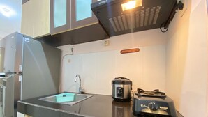 Eine kleine Küche mit Spüle, Reiskocher und Toaster.