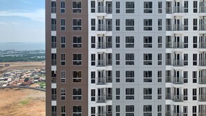Un immeuble de grande hauteur doté de nombreux balcons et offrant une vue sur une zone côtière.