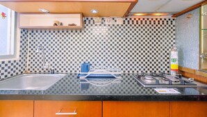 Une cuisine avec un dosseret à carreaux, un évier, une cuisinière et des armoires en bois.