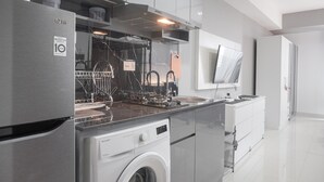 Een moderne keuken met roestvrijstalen apparatuur, een vaatwasser en een ingebouwde wasmachine.