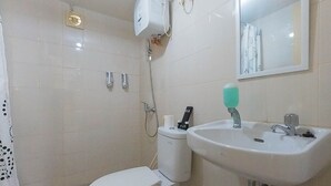 Un baño con inodoro, lavamanos y ducha.