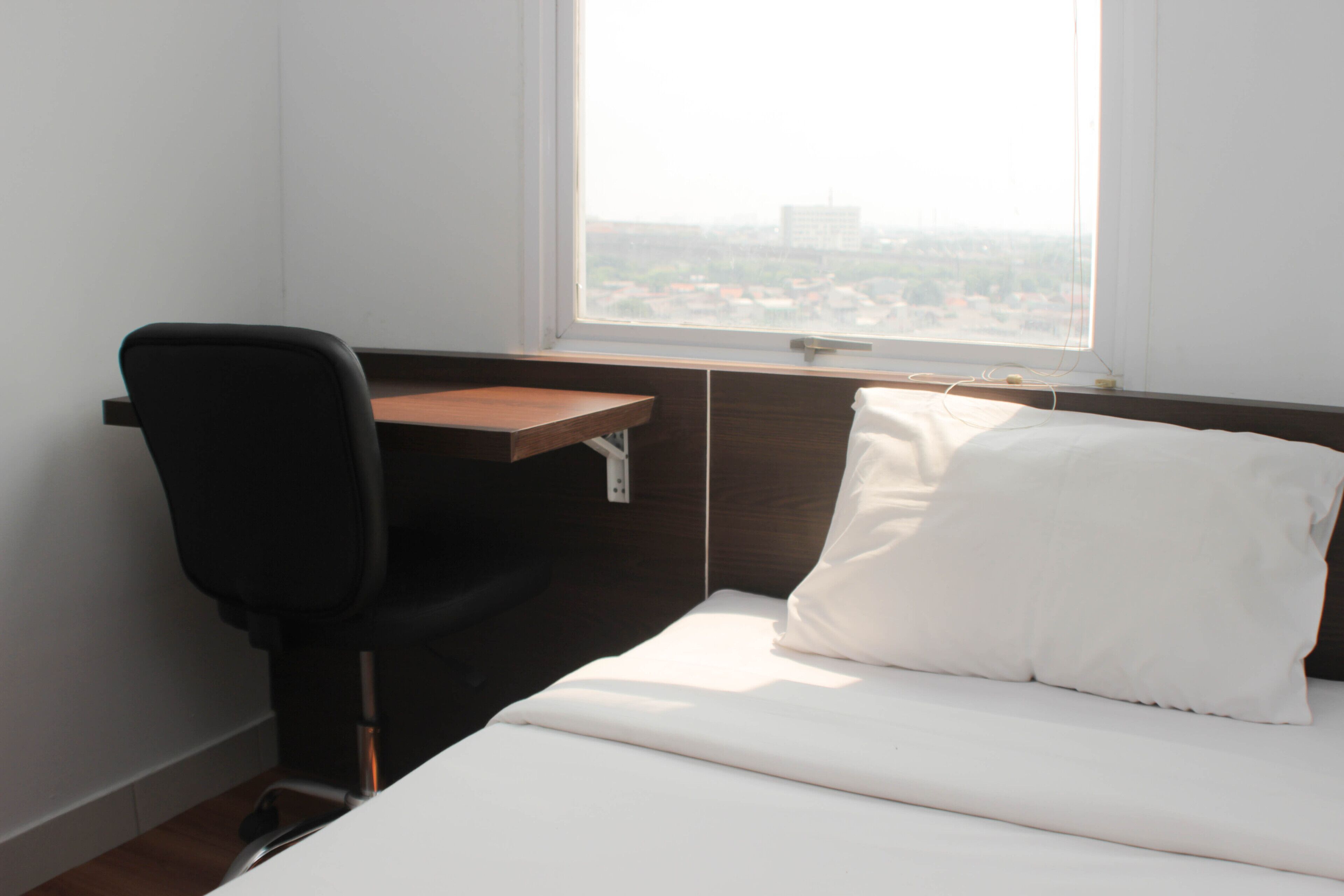 Un dormitorio con una cama, un escritorio y una silla.