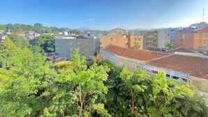 A cityscape with buildings, trees, and a clear sky. - Cozy And Serene 2Br Apartment At Parahyangan Residence (Bandung)