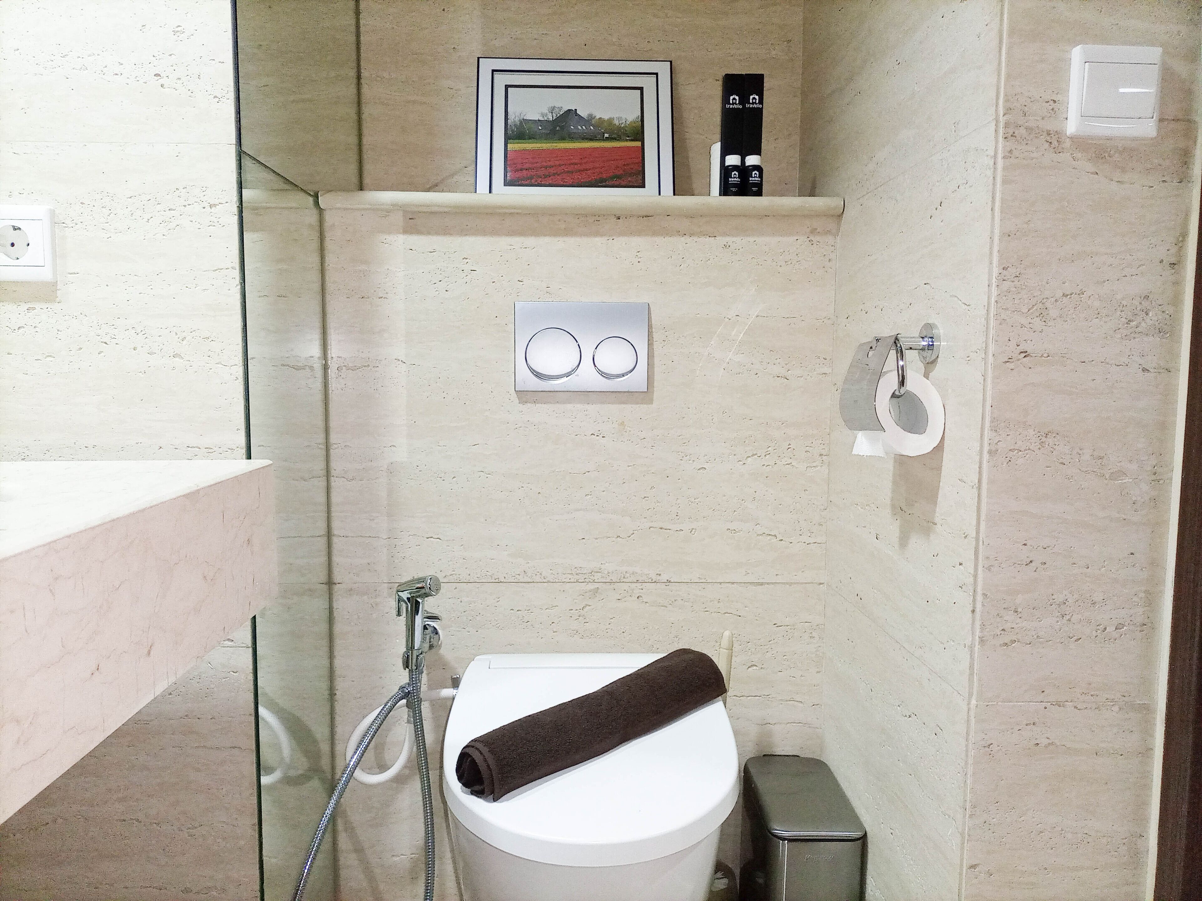 A bathroom with a toilet, a shower, and a towel.