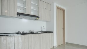 Een moderne keuken met licht houten kastjes, een roestvrijstalen spoelbak en een zwarte afzuigkap.