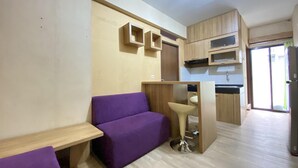 A compact kitchen with wooden cabinets and a built-in sink. - Cozy 3Br Furnished Apartment At Gateway Ahmad Yani Cicadas (Bandung)