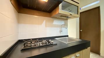 Frigorífico, placa de cocina, utensilios de cocina y mesa de comedor