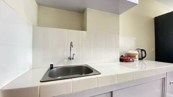 Frigorífico, placa de cocina, utensilios de cocina y mesa de comedor