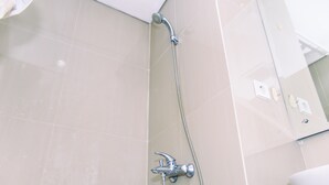 A bathroom with a shower, a sink, and a mirror. - Nice And Cozy Studio At Paramount Skyline Serpong Apartment (Gading Serpong)
