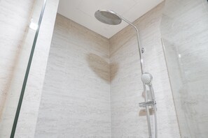A shower with a handheld showerhead and a wall-mounted control. - Warm And Elegant 1Br At Gold Coast Apartment (Jakarta)