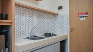 Une cuisine moderne avec un dosseret de carrelage hexagonal, un évier en acier inoxydable et un lave-vaisselle encastré.