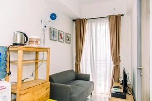 Cozy living space with a sofa, wooden shelf, and flat-screen TV.