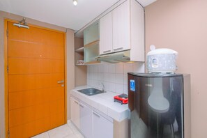 Fridge, stovetop, cookware/dishes/utensils, dining tables - Warm And Cozy Stay Studio Apartment Margonda Residence 2 (Depok)