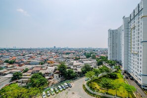 A high-rise building with multiple floors, surrounded by a densely packed urban area with various buildings and greenery.