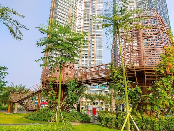 A modern building with a unique cylindrical structure and a bridge connecting two sections.