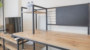 Ein Etagenbett mit Holztablett und Metallgestell, eine Wasserflasche auf dem Regal und eine Fernbedienung auf dem Tisch.