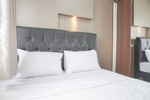 A neatly made bed with a tufted headboard, white bedding, and a mirror on the wall. - Nice And Cozy 2Br At Cinere Resort Apartment (Depok)