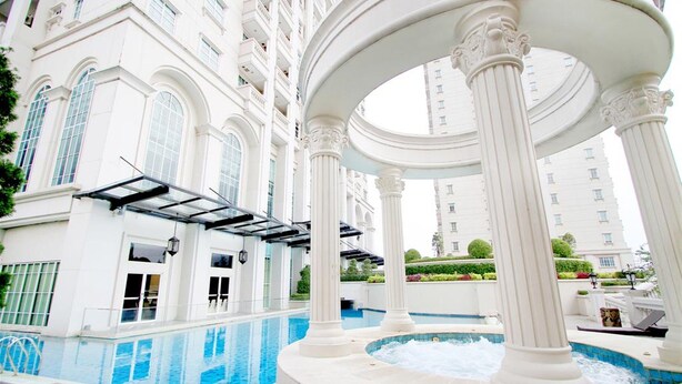A luxurious indoor pool area with classical architecture, including columns and a pergola. - Cozy Stay And Tidy 1Br At The Bellezza Apartment (Jakarta)