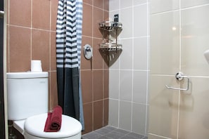 A bathroom with a toilet, a shower, and a towel rack. - Minimalist 1Br Apartment With Pool View At Atlanta Residences (Depok)