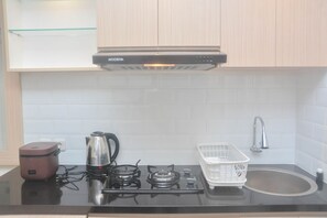 Fridge, stovetop, cookware/dishes/utensils, dining tables - Scenic 2Br Bassura City Apartment Near Shopping Mall (Jakarta)