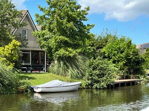Enjoy a tranquil riverside retreat with a house nestled among lush greenery and trees.