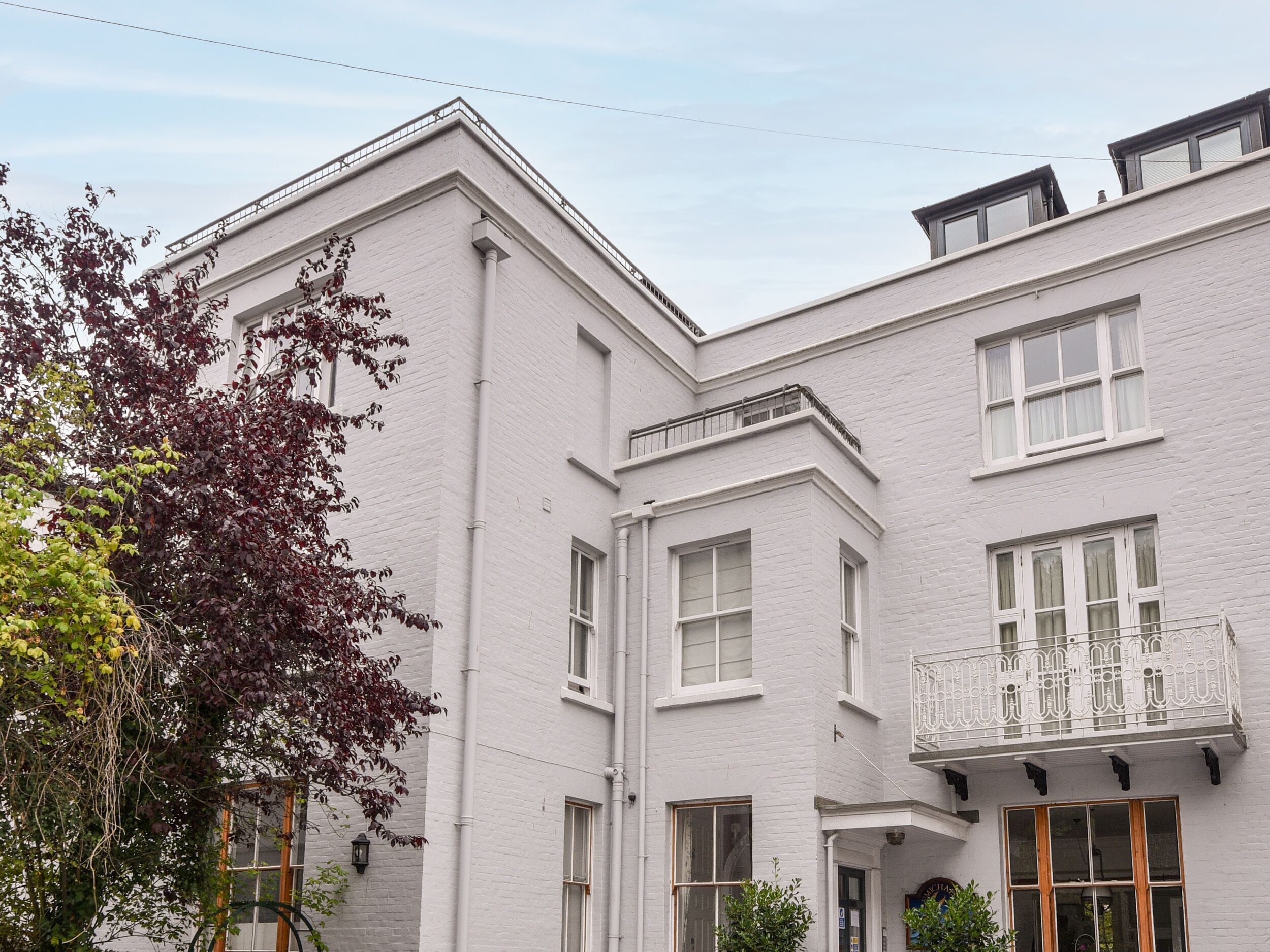 A white building with multiple windows and a balcony.