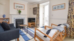 Un salon avec une cheminée, un téléviseur et un canapé.