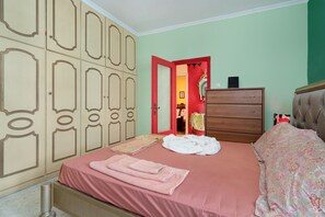 Une chambre à coucher avec un lit, une commode et une armoire.
