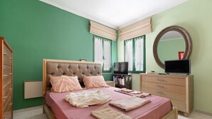 A bedroom with a bed, dresser, television, and a mirror. - Villa Maria and Dimosthenis with Garden & Wi-Fi (Kalamata)