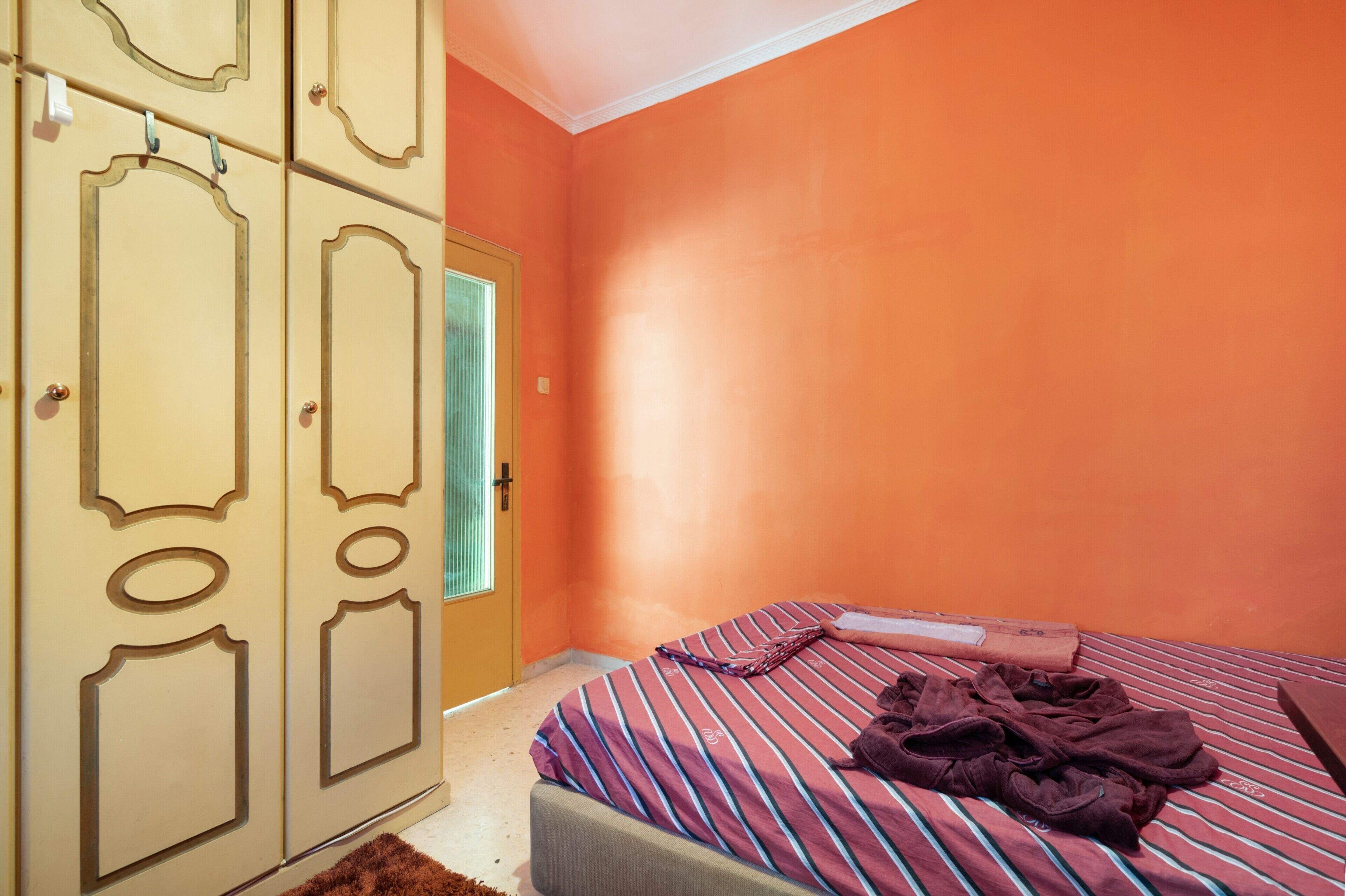 Ein Schlafzimmer mit einem Bett, einem Kleiderschrank und einer Tür.
