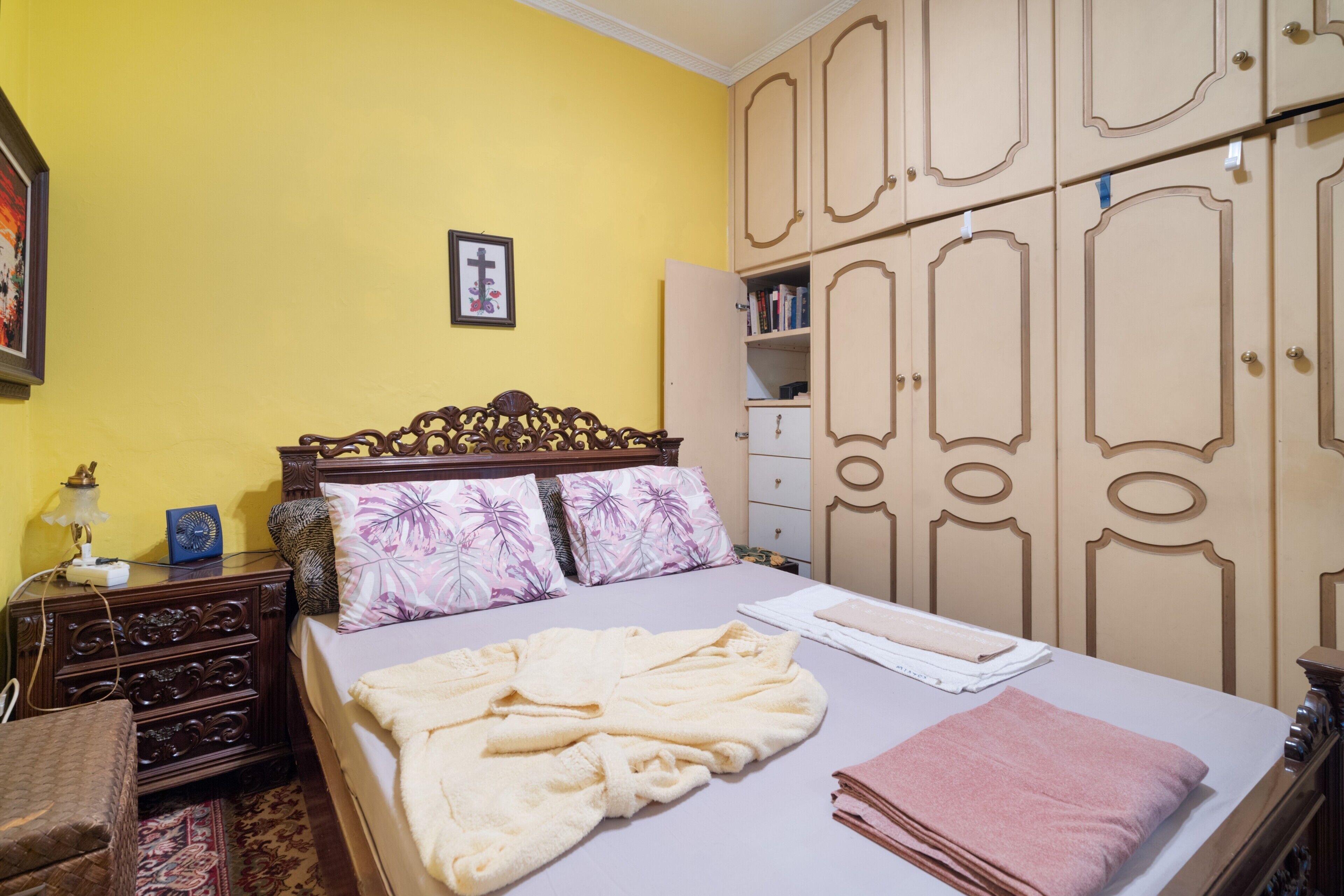 Ein Schlafzimmer mit Bett, Holzschrank und Nachttisch.