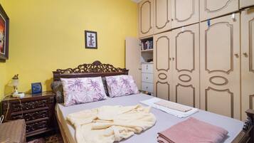 Ein Schlafzimmer mit Bett, Holzschrank und Nachttisch.
