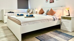 Un dormitorio con cama, mesitas de noche, lámpara y ventana.