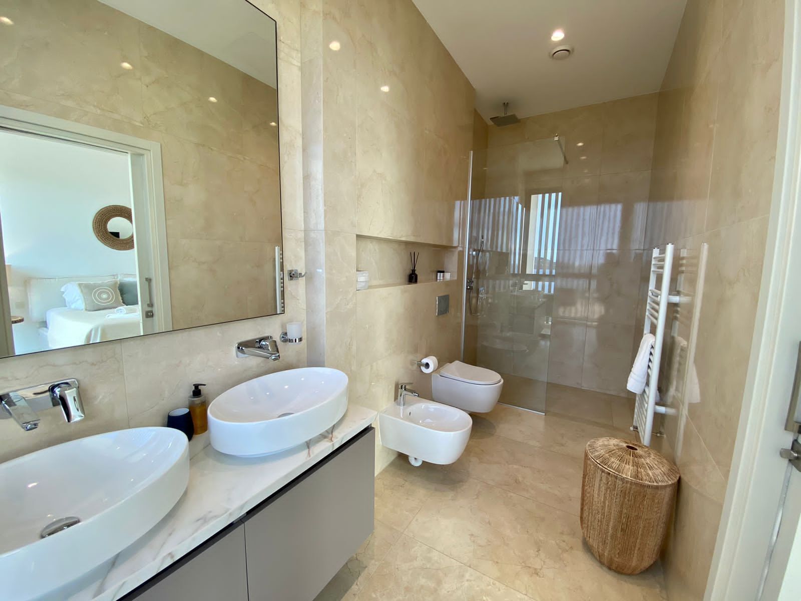 Une salle de bain moderne avec deux lavabos, des toilettes et une douche.