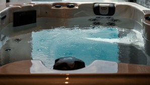 Un bain à remous avec vue sur un paysage rocheux, visible à travers une fenêtre.