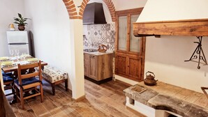 A cozy kitchen with a wooden bench, a built-in oven, and a tiled backsplash.