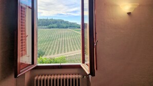 A room with an open window overlooking a field.