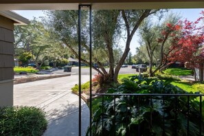 Una calle residencial con casas, un camino de entrada y un jardín bien cuidado.