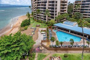 Um resort com piscina, praia e palmeiras.