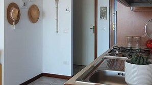 Eine Küche mit Spüle, Herd und einem Essbereich mit Waage, Tasse und Bechern.
