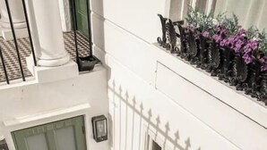 A staircase with a metal railing, a green door, and a white fence with windows. - Miss Westside Story - by Out of Office Lifestyle (Greater London)