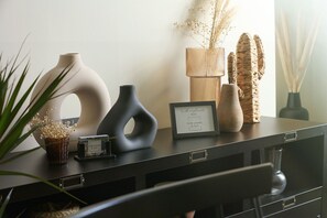Ett svart skrivbord med vaser, en inramad skylt och en liten klocka.