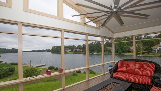 A spacious balcony with a view of a lake, a ceiling fan, and outdoor furniture. - Pinehurst Lake House Retreat - Pinehurst Lake Front Property With a Pool (Pinehurst)