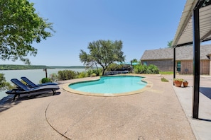 Relax by the pool with a serene lake view.