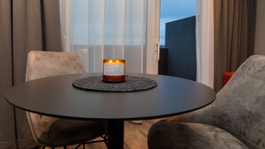 Una mesa redonda con una vela en el centro, rodeada de sillas tapizadas en gris.